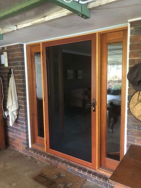 Timber-framed security door with sidelights on verandah